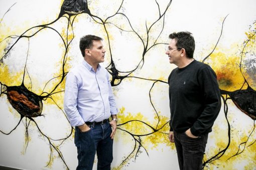 José Lucas y Raúl Méndez, ante un mural de neuronas en el Instituto de Investigación Biomédica de Barcelona. Foto: Xavier Cervera, La Vanguardia